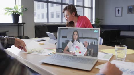 Caucasian-businessman-on-laptop-video-call-with-african-american-fefmale-colleague-on-screen