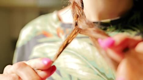 close up of woman braiding hair in warm sunlit room, peaceful and intimate