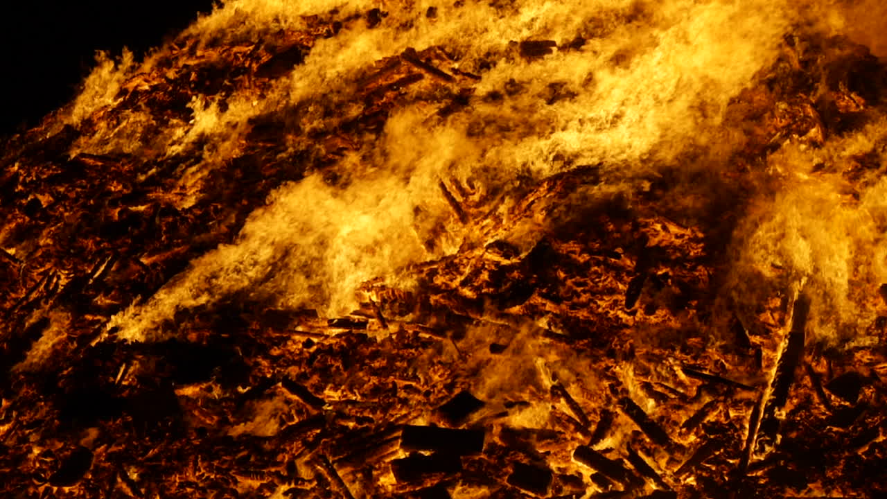 Eine mittlere, meist statische Aufnahme eines riesigen Lagerfeuers, das in Zeitlupe brennt, aufgenommen mit 180 Bildern pro Sekunde.
