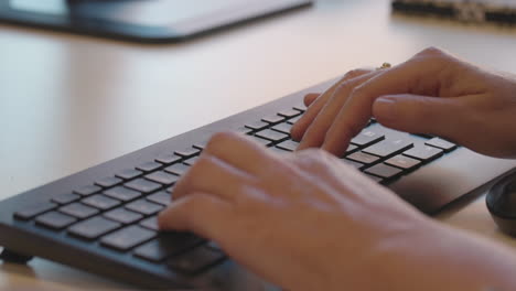 close of woman hands typing at a computer keyboard