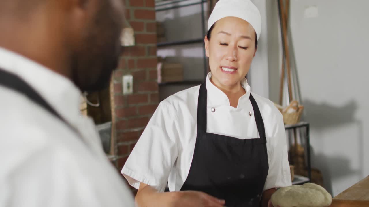 アジアの女性パン屋が同僚にパンを作る方法を説明するアニメーション