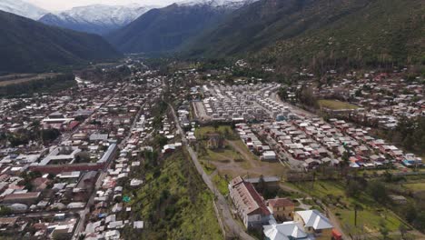 aerial view of a town in a valley with snow-capped mountains