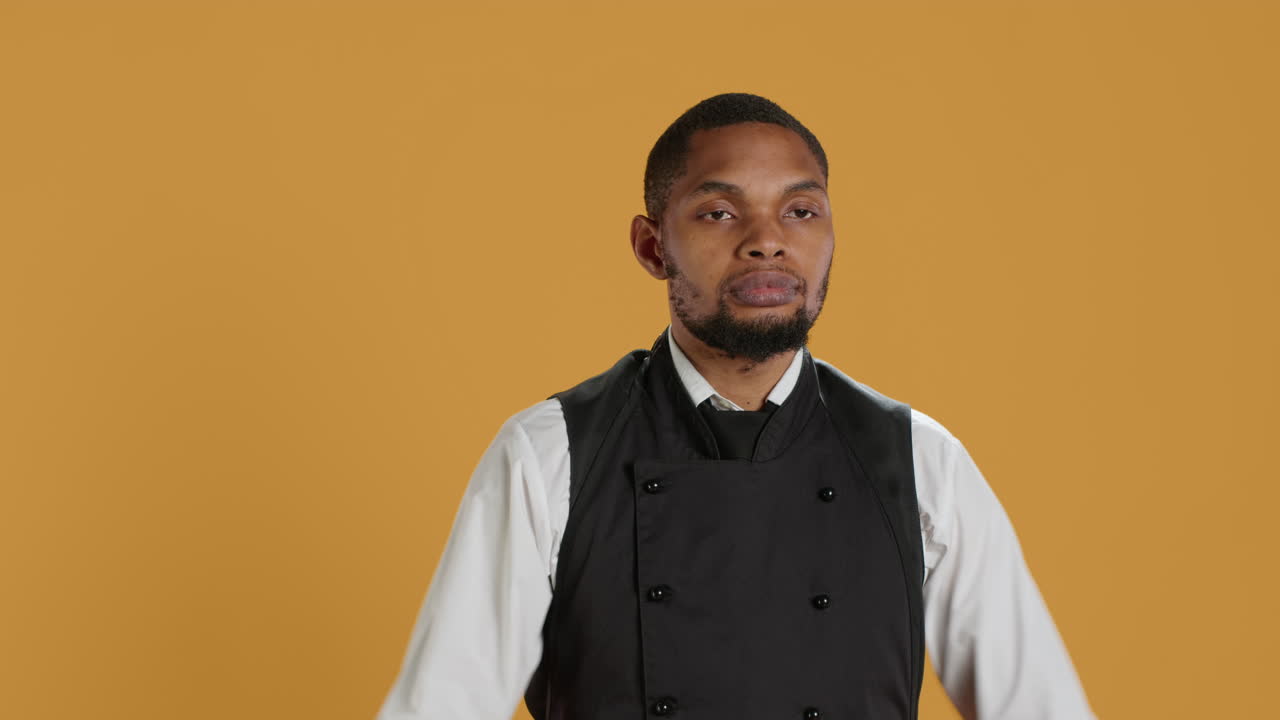 serio desagradecido camarero da un pulgar hacia abajo señal en el estudio