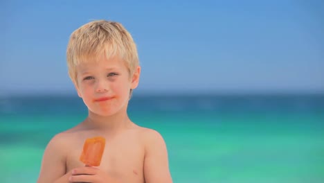 un niño sonriente comiendo hielo de agua