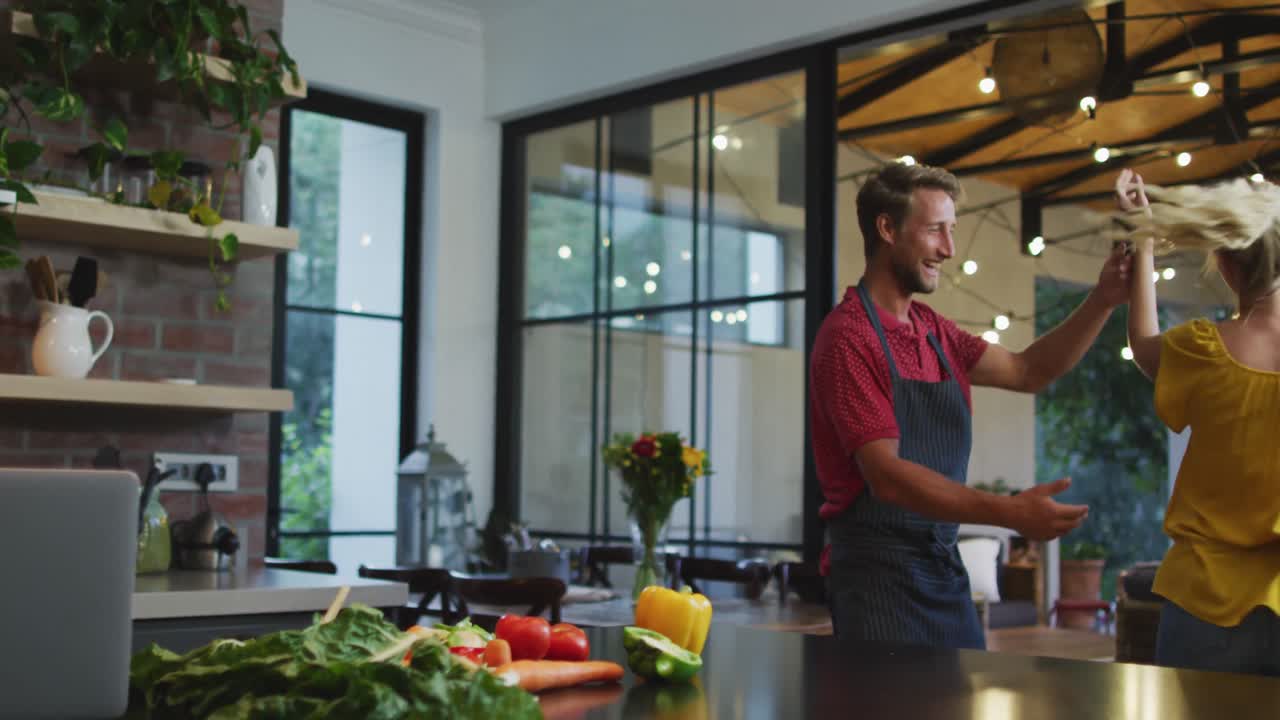 pareja feliz bailando en la cocina