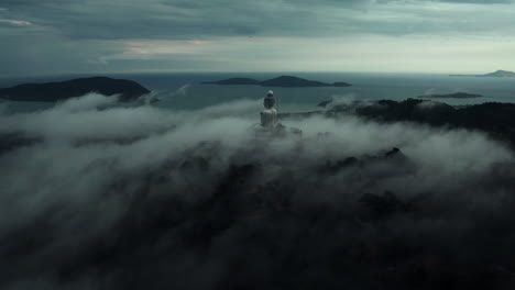 misty sunrise view of a giant buddha statue in thailand