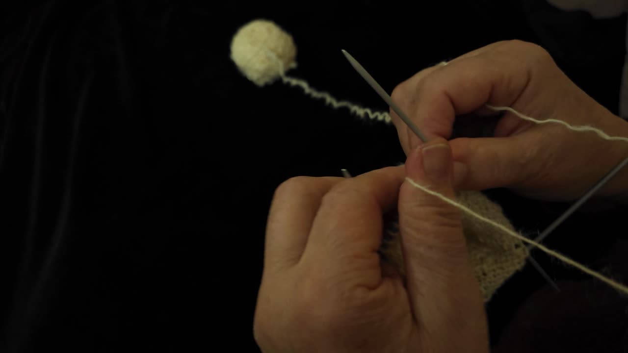 Grandmother Crafting Socks with Traditional Spears, Using Natural Sheep's Wool, with a Yarn Skein as Backdrop
