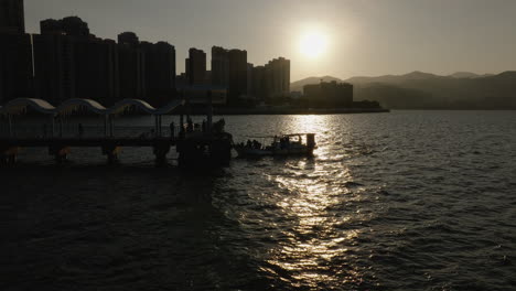 Paisaje-Urbano-Aéreo-De-Hong-Kong-Durante-La-épica-Puesta-De-Sol-Con-Barco-En-El-Muelle-Del-Puerto-Principal