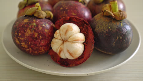 Frutas-Frescas-De-Mangostán-Maduras-En-Un-Plato-Blanco