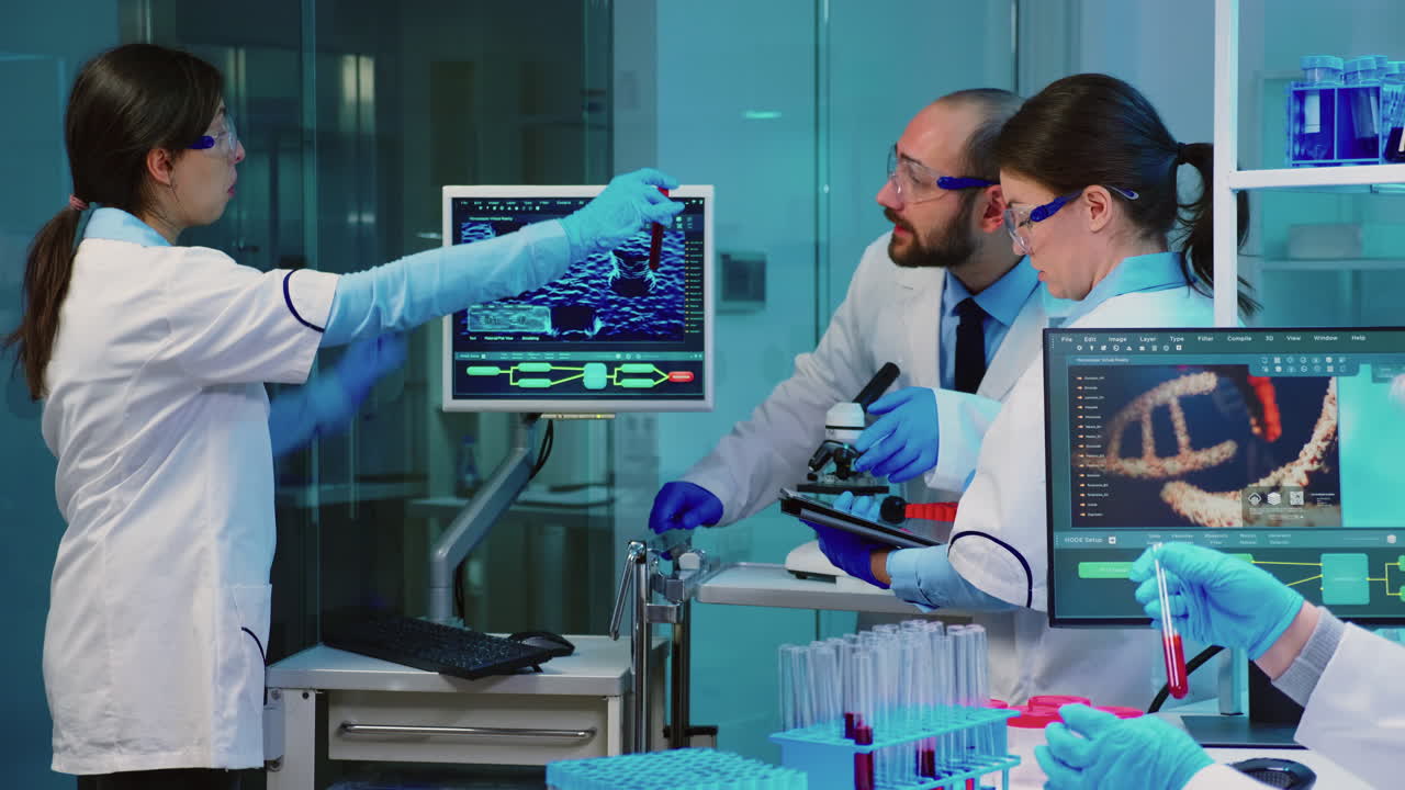 chimico senior che analizza un campione di sangue mentre i colleghi discutono