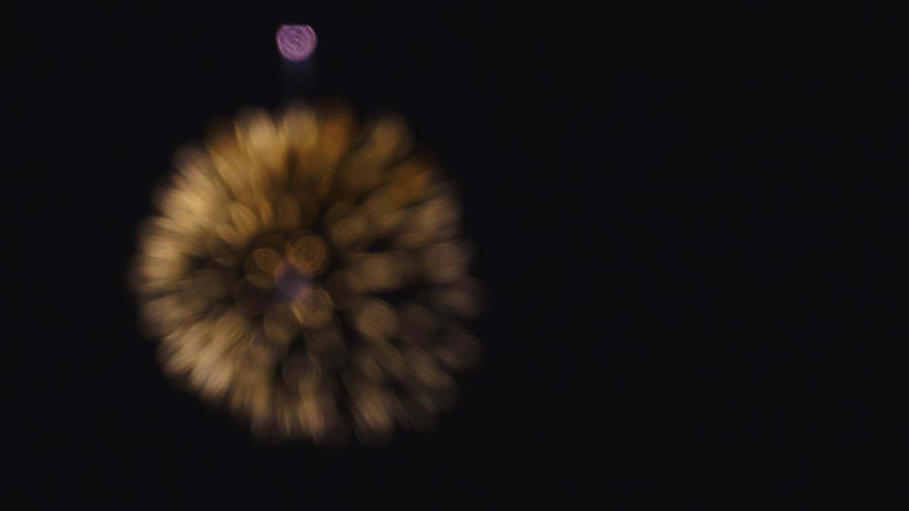 실제 불꽃놀이 배경의 원활한 루프: 밤하늘에 보케 조명과 함께 실제 황금빛 반이는 불꽃 놀이의 추상적인 흐릿함.