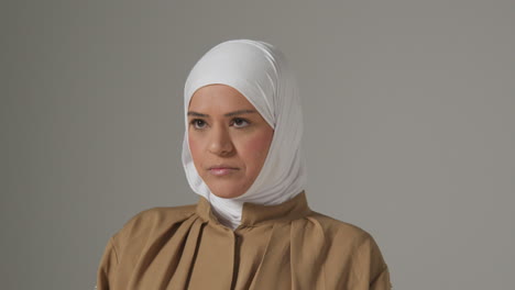 studio portrait of muslim woman wearing hijab against plain background