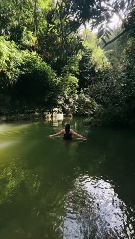 person swimming in a jungle pool