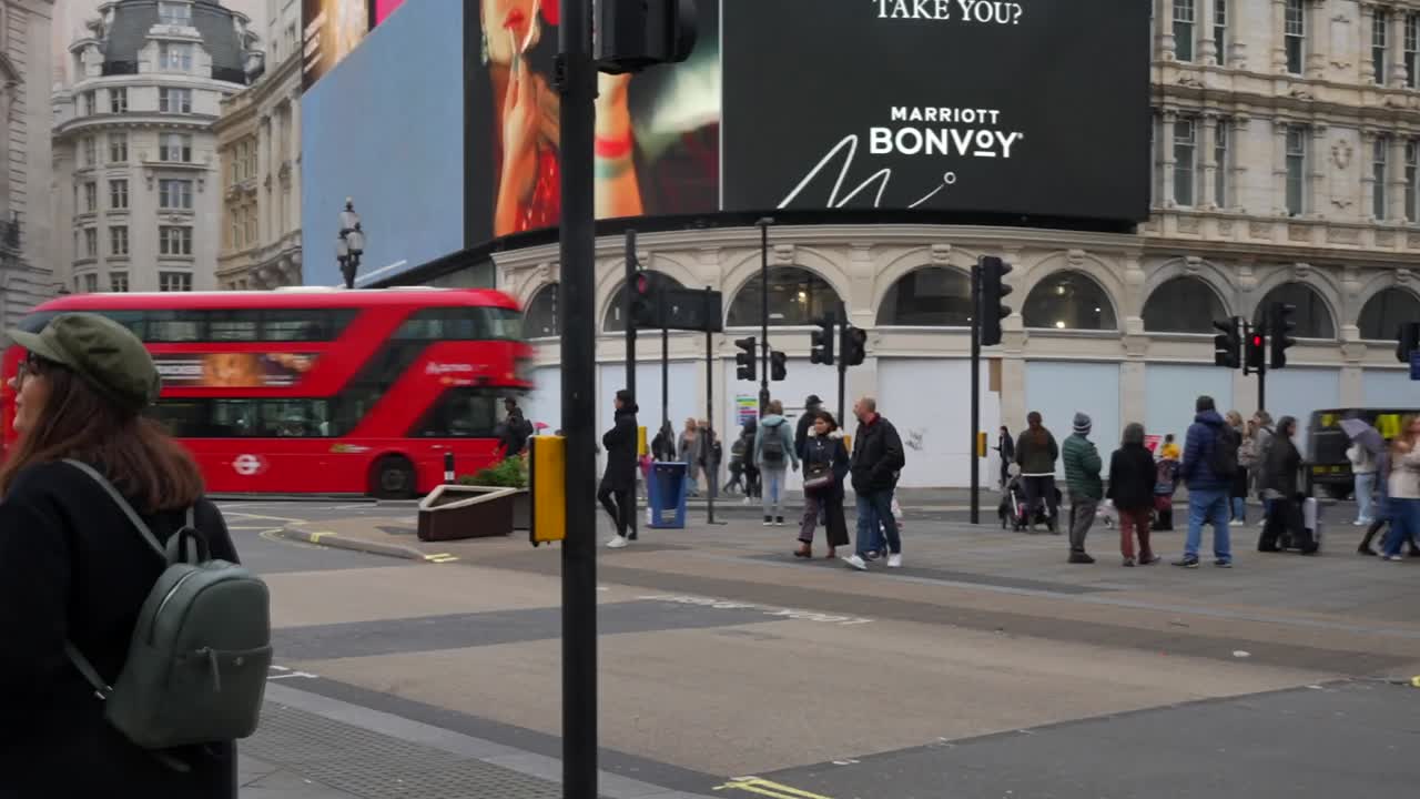 Bustling Piccadilly Circus with iconic red bus, advertising screens, and people walking through London