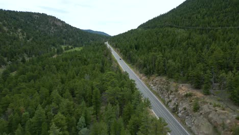 Bajando-En-La-Carretera-En-Las-Montañas-Con-Matorrales-Densos-Cerca-Del-Parque-Estes-En-El-Norte-De-Colorado,-Ee.uu.