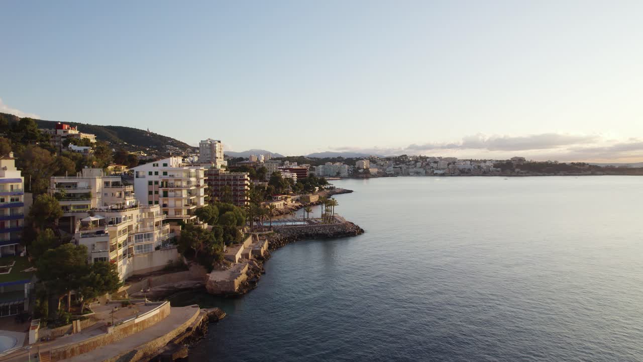 Luxurious hotel buildings covered in morning sunlight, aerial dolly in Mallorca