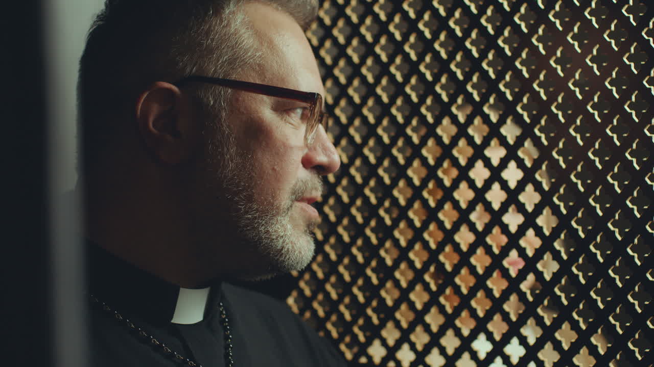 Senior Priest Talking to Penitent during Confession in Church