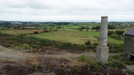 Parys-mountain-abandoned-brick-chimney-copper-mining-mill-stone-ruin-aerial-view-long-dolly-right