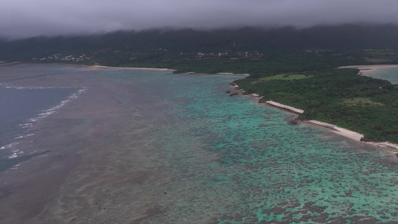 Filmato aereo orizzontale con carrellata in avanti sopra la barriera corallina, la costa e il litorale turchese dell'Isola di Kojima e della Baia di Kabira, Isola di Ishigaki, Okinawa, Giappone