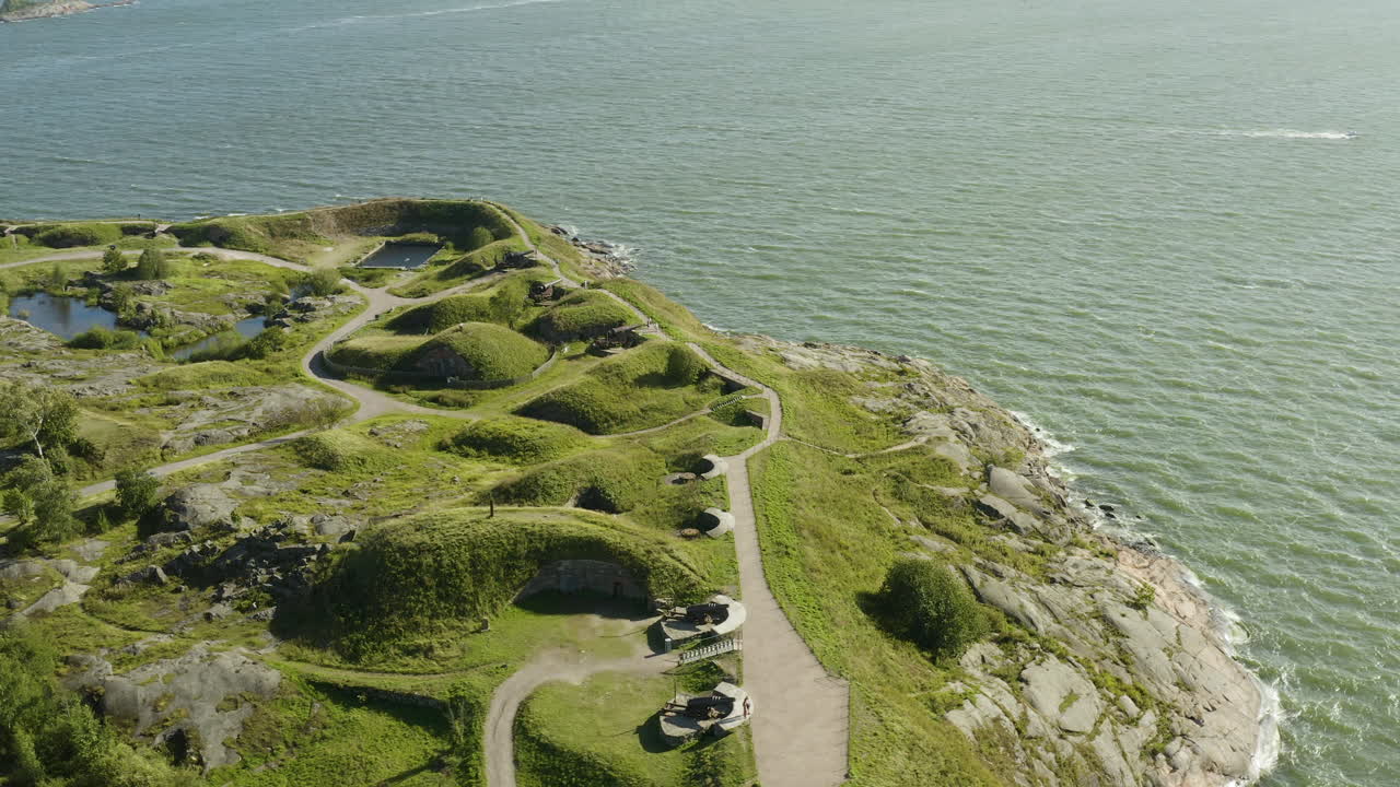 Luftaufnahme um die Kanonen und die Südküste der Festungsinsel Suomenlinna an einem sonnigen Sommertag in Helsinki, Finnland – Orbit, Drohnenaufnahme.