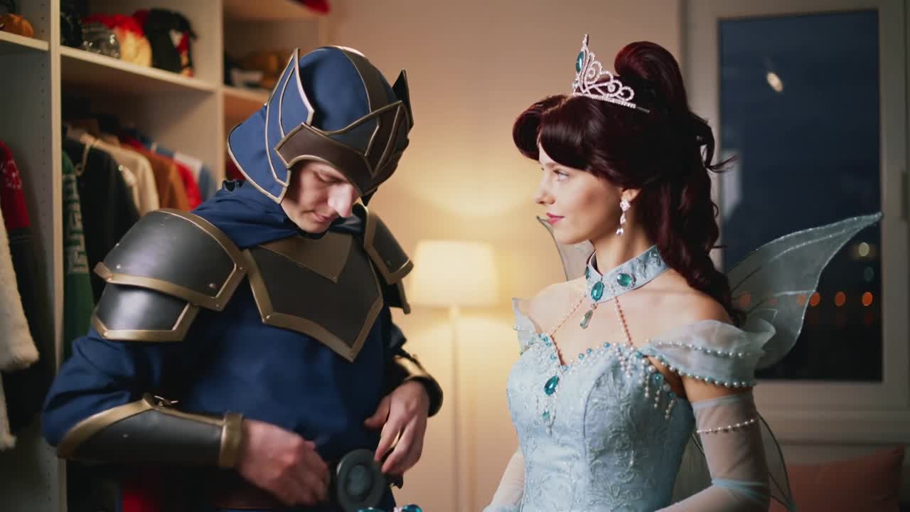 Cavaleiro prendendo, ajudando princesa a segurar pingente no camarim, preparando-se para festa à fantasia.