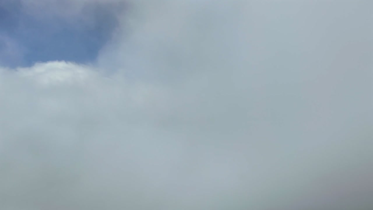 Exclusive shot taken from a jet airplane cockpit flying through ethereal fluffy cluds in a blue sky. Ultra-realistic 4K shot