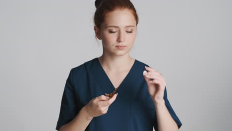 redheaded doctor in front of camera on gray background.