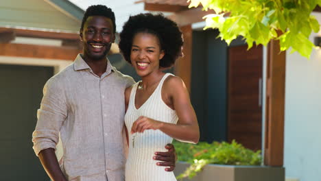 portrait of couple outdoors holding keys to dream home