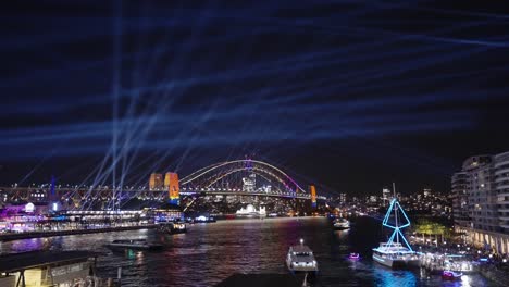 Boats-passing-the-Harbour-bridge-during-Sydney's-Vivid-light-festival-Wide-Shot