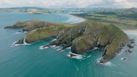 panoramablick aus der luft auf eine zerklüftete und felsige landschaft, die sich bis in den ozean erstreckt, in der abgelegenen wildnis von cannibal bay, catlins, südinsel neuseeland, aotearoa