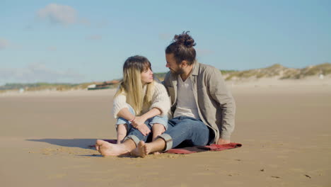 Liebendes-Kaukasisches-Paar,-Das-Am-Strand-Sitzt