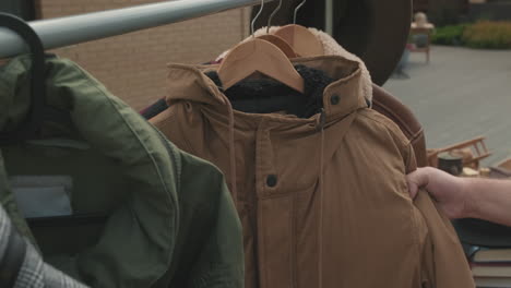 man choosing jacket at garage sale