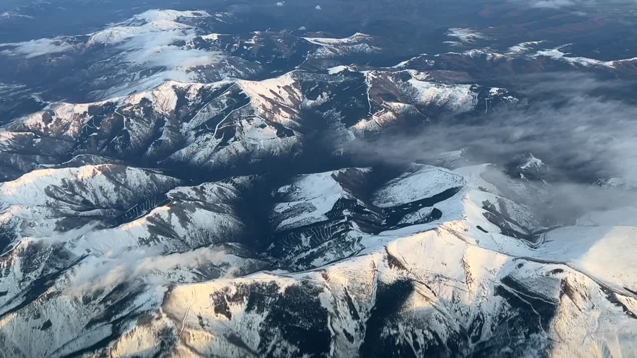 vista aérea desde la cabina de un jet sobrevolando montañas nevadas en el norte de españa
