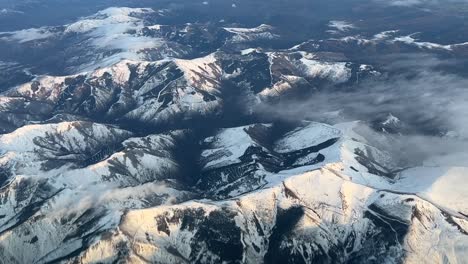 Vista-Aérea-Desde-La-Cabina-De-Un-Jet-Sobrevolando-Montañas-Nevadas-En-El-Norte-De-España