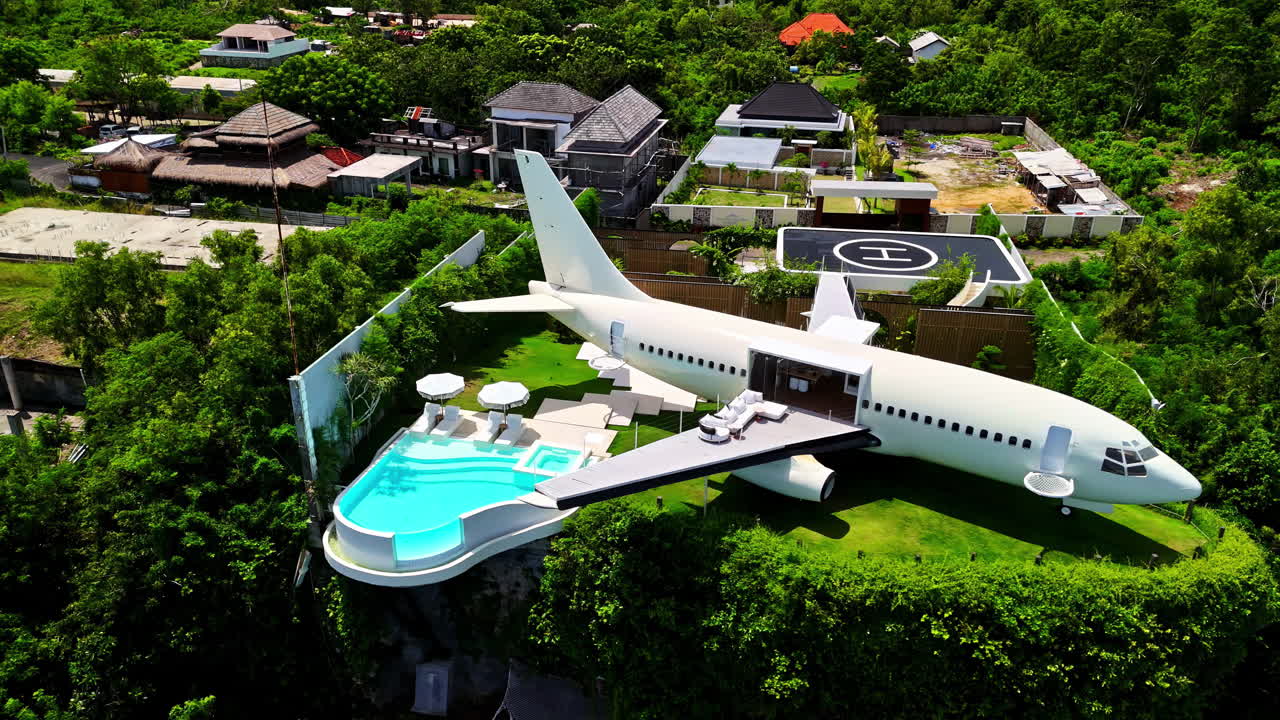 Drone view of unique airplane villa with infinity pool on cliff at Nyang Nyang Beach, Bali