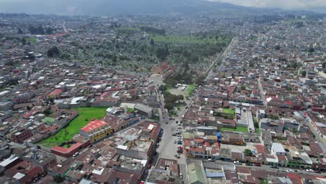 imágenes aéreas de drones del tráfico colonial urbano conduciendo por las calles de la ciudad centroamericana de las tierras altas de quetzaltenango, xela, guatemala en un día soleado cerca del parque el calvario y el cementerio general