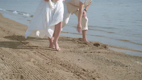 pregnant couple having fun on beach. feet of couple on beach