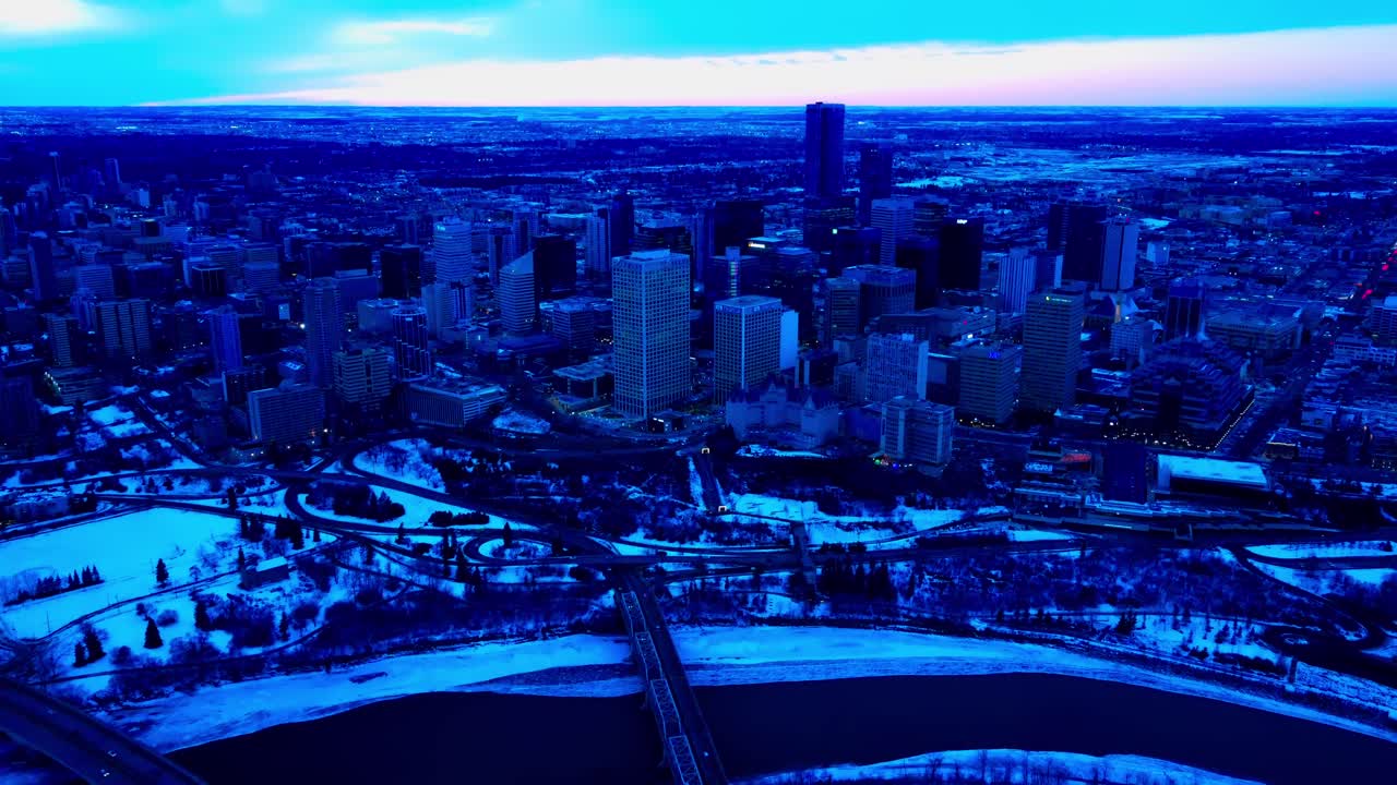 4k twilight edmonton winter city vuelo aéreo inverso de drones en el centro sureste centrado desde el hotel fairmont macdonald con vista al puente de bajo nivel y al río saskatchewan del norte 1-2