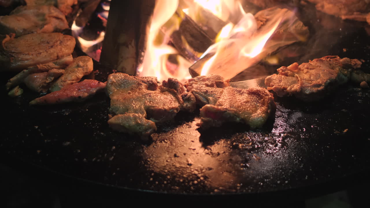 캠프 불 에 구워진 고기 를 요리 하는 것