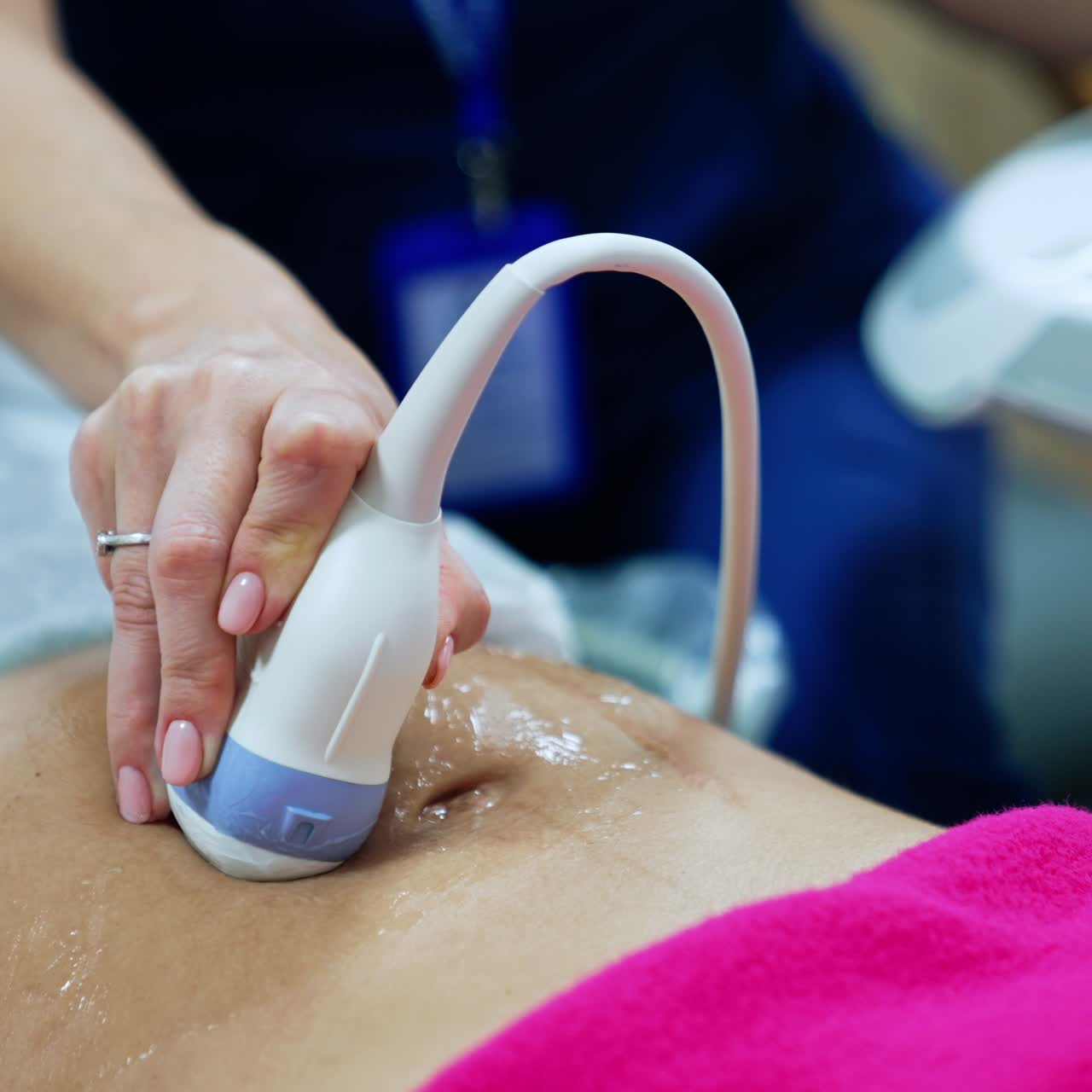 Obstetrician holds the ultrasound device on the patient's pregnant belly. Woman is checked in the clinics. Close up