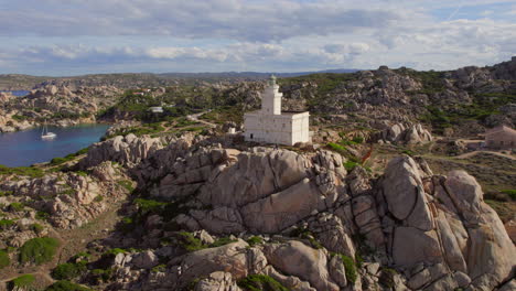 aerial view in a circle over the lighthouse located on cape testa and the beautiful beach that can be seen