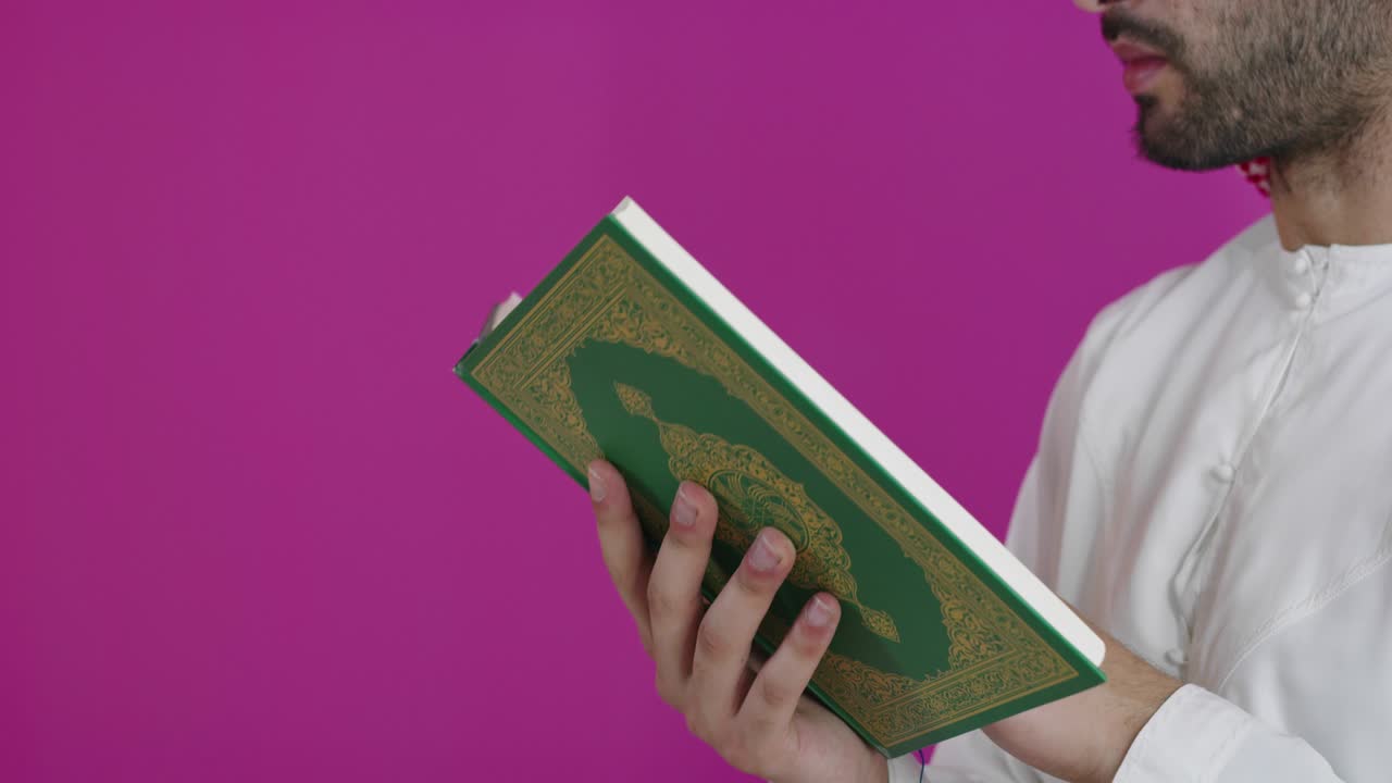 Nuori arabialainen muslimimies perinteisissä vaatteissa rukoilemassa ja lukemassa Koraania