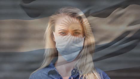 Animation-of-flag-of-argentina-waving-over-caucasian-woman-wearing-face-mask-in-city-street