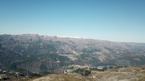 aerial view over green nature and hills, towards steep mountains and bright sunlight