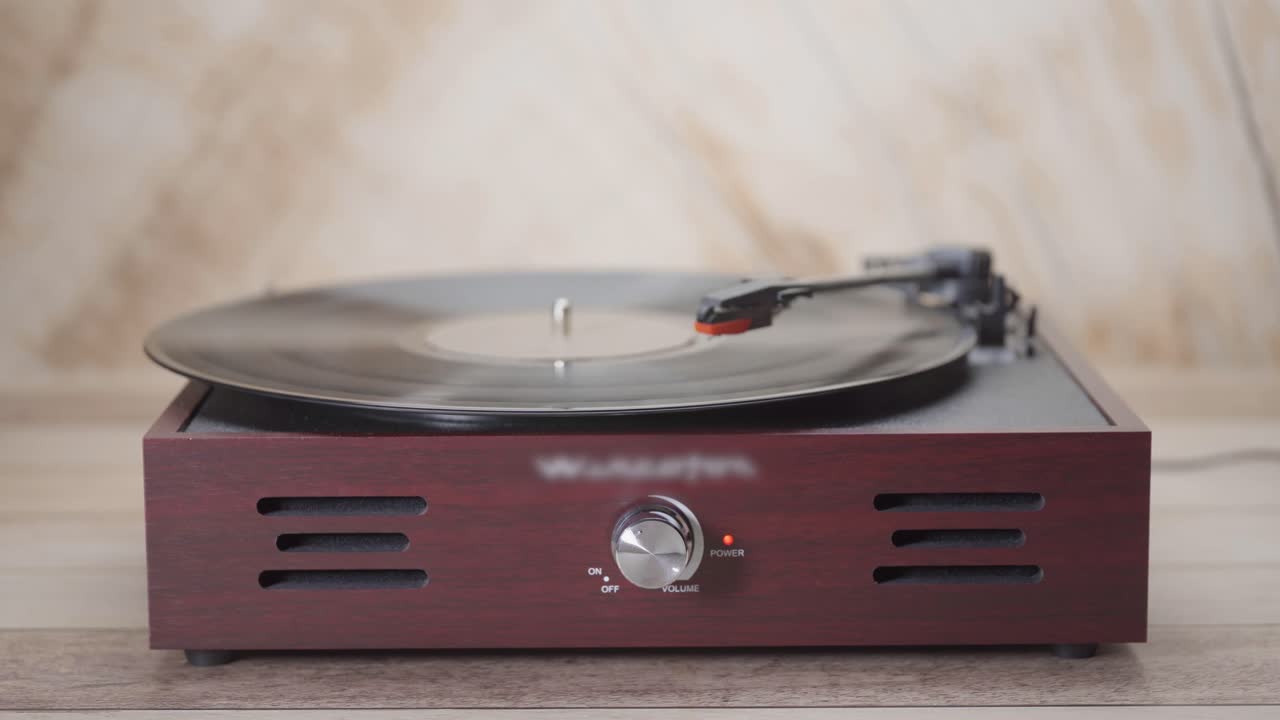 Hand die een vinylplaat aanzet en afspeelt op een draaitafel