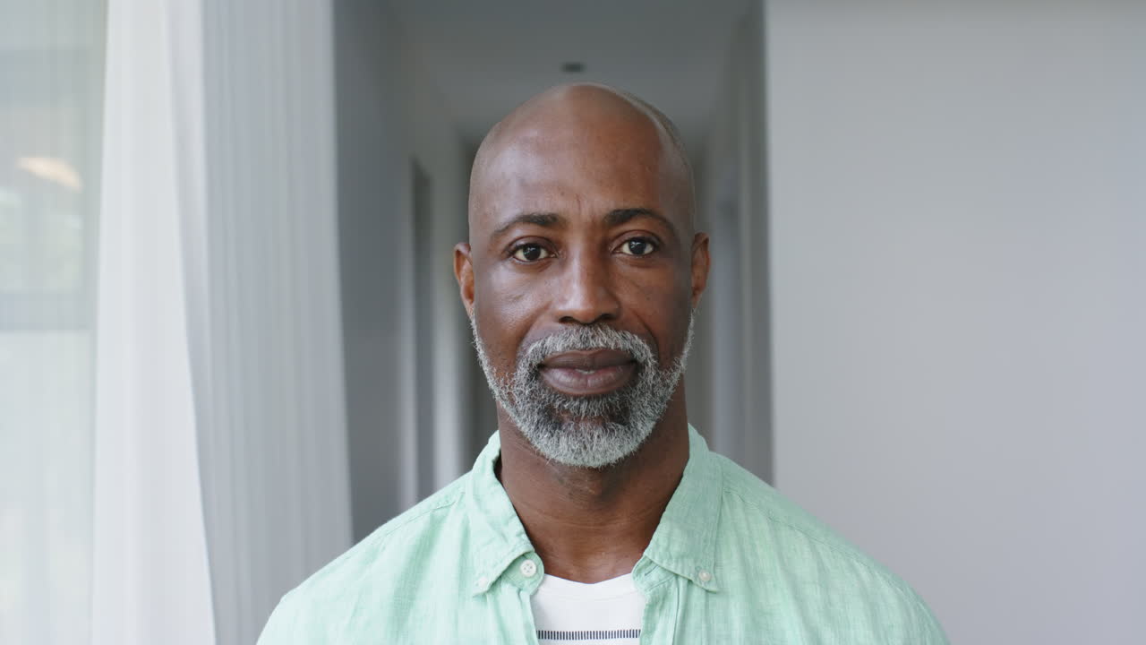 retrato de un hombre feliz de dos razas con barba gris en casa, en cámara lenta
