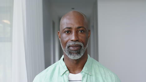 Portrait-of-happy-biracial-man-with-gray-beard-at-home,-slow-motion