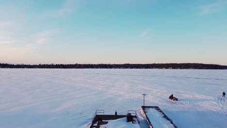 Vierrad-ATV,-Das-Während-Des-Sonnenuntergangs-Auf-Der-Gefrorenen,-Schneebedeckten-Seestraße-Fährt