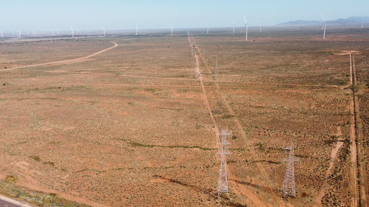 toma aérea de drones de líneas eléctricas y autopista de granja de energía eólica solar en el interior con cielo terreno accidentado viajes turismo puerto augusta adelaida sur de australia 4k