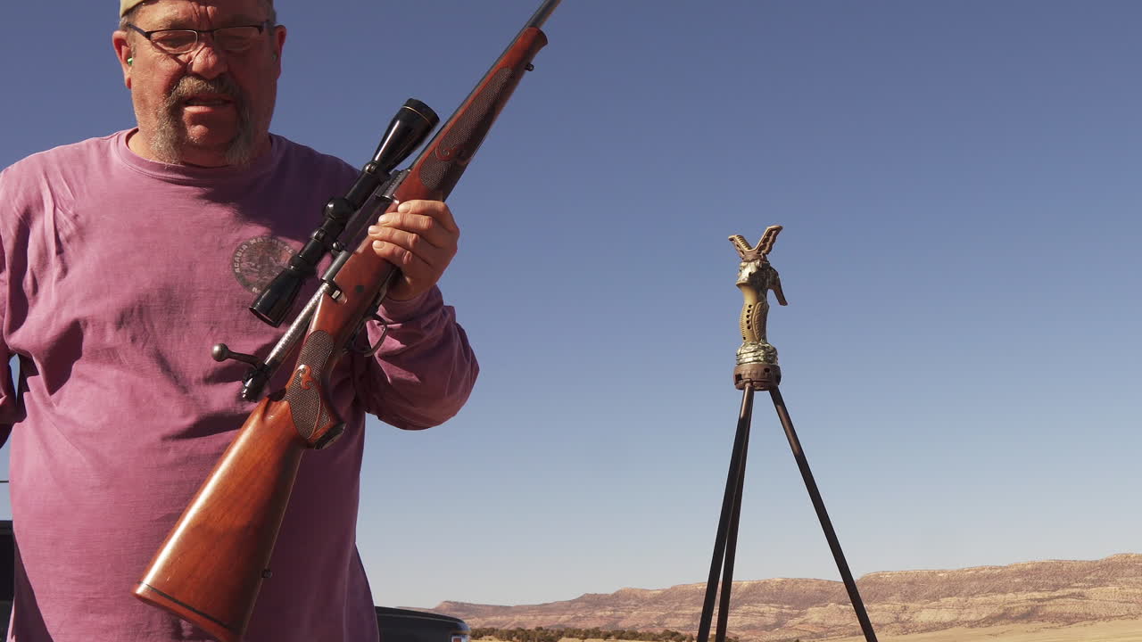 el hombre borra su rifle después de disparar